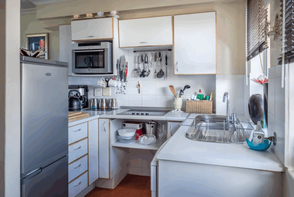 A well-organized kitchen with modern appliances and utensils hanging on the wall.